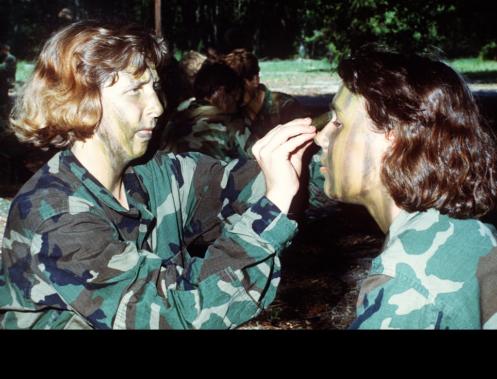 Women Marines apply camouflage makeup before a field exercise. (U.S. Marine Corps photo. Public Domain)