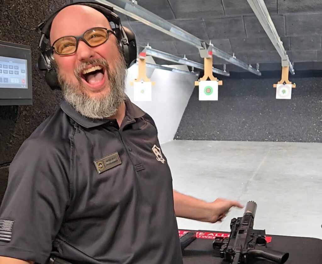 A man laughs at an indoor firing range