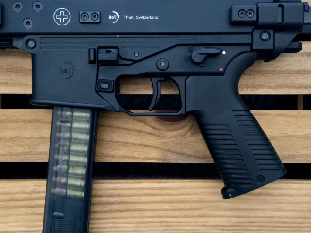 The lower half of a firearm loaded with hollow point ammunition on a wooden crate