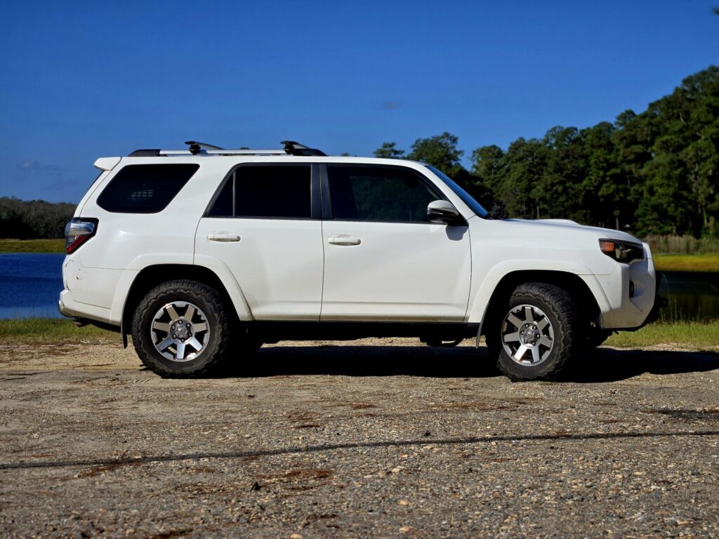 A white Toyota 4Runner parked next to a lake