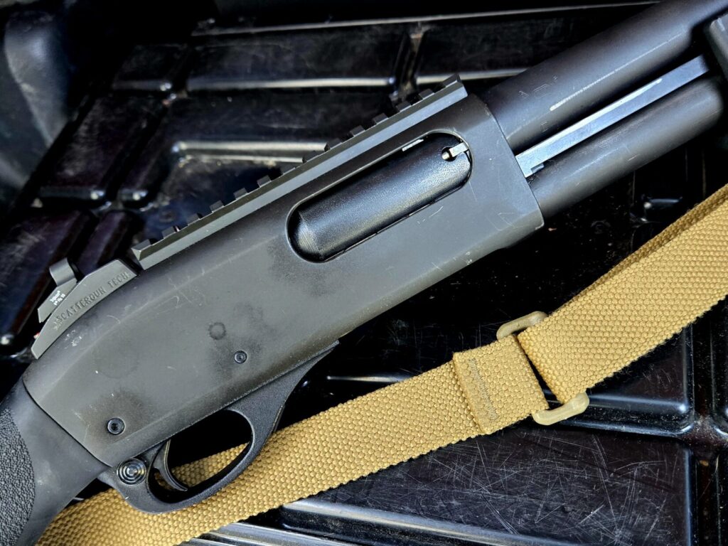 A remington 870 shotgun receiver with a picatinny rail and blue force gear Vickers Sling