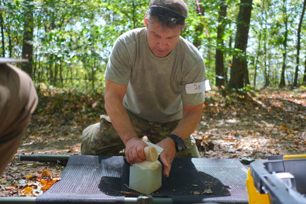 competitor pushes gauze into a wound cube at the trauma care stage