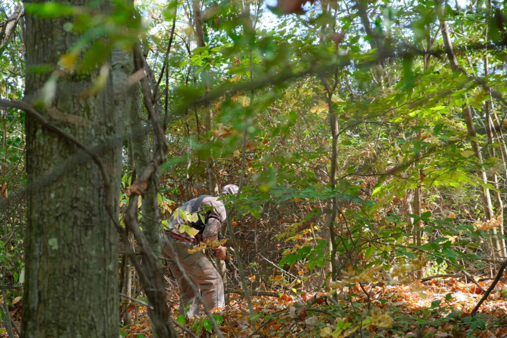 man enters the woods to begin the stalk to an objective