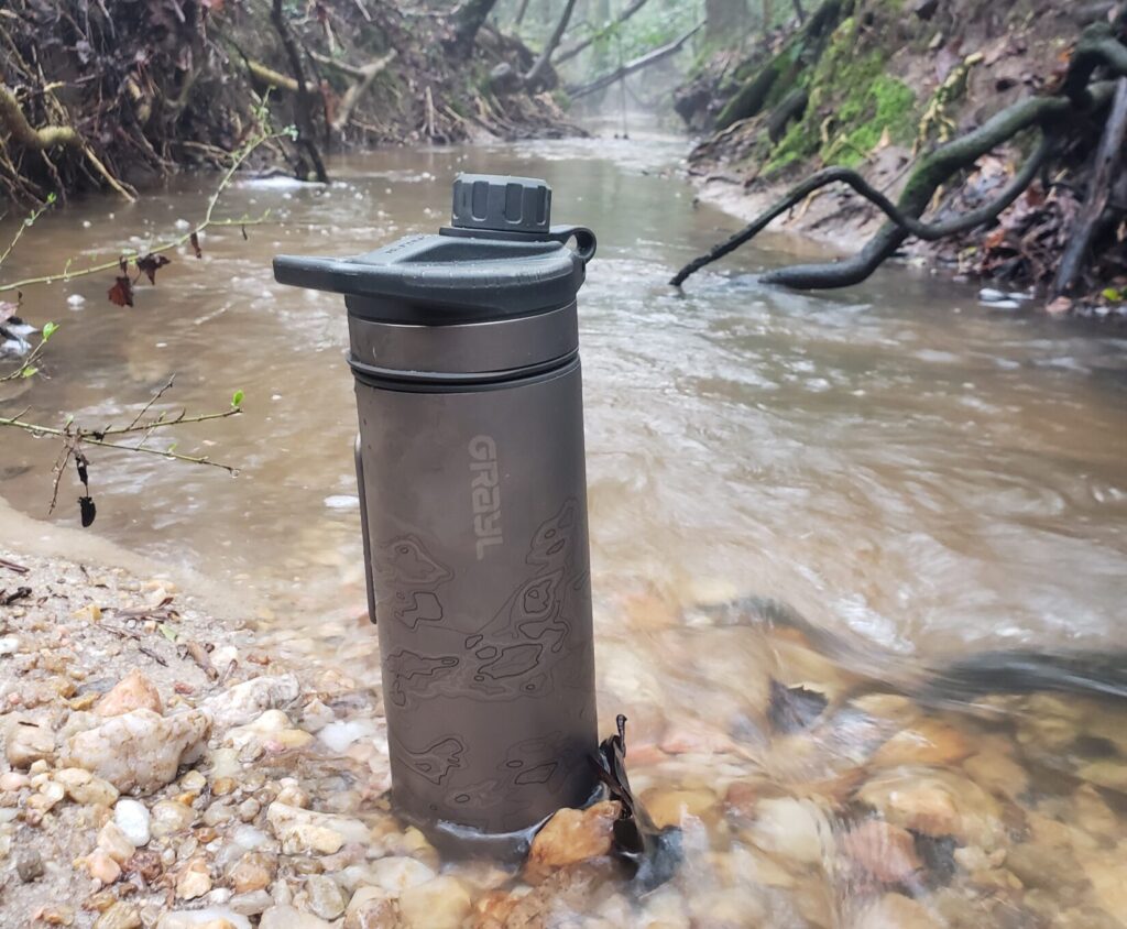 Grayl water filter next to a running creek