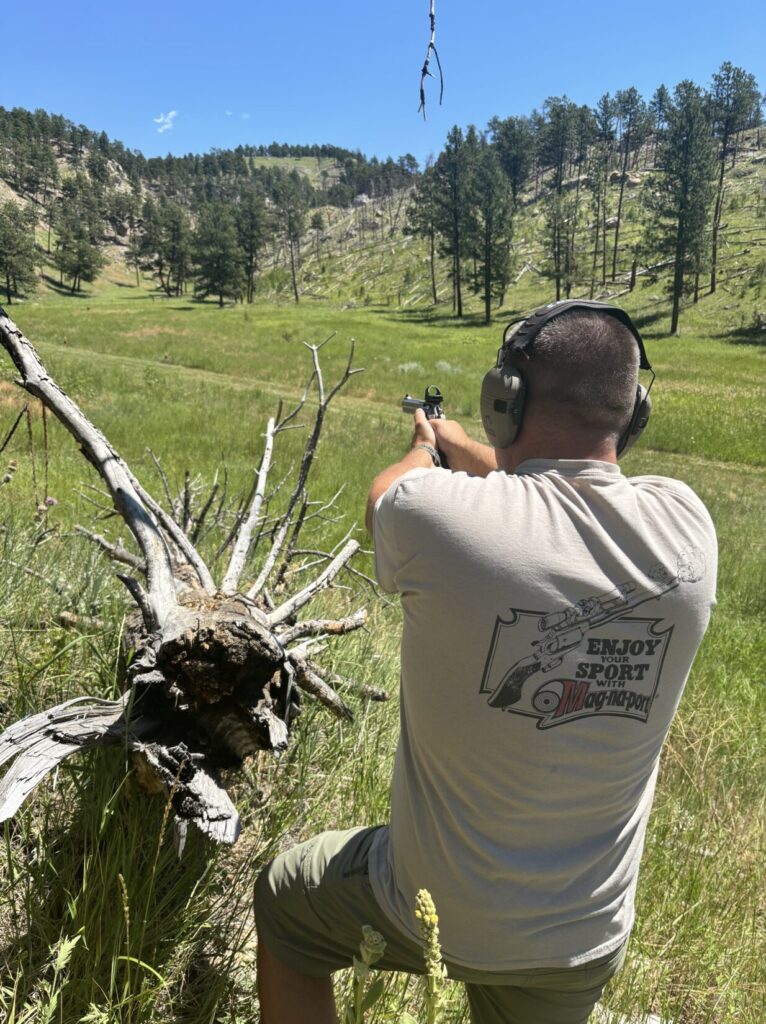 man wearing hearing protection, Field shooting positions with revolver.