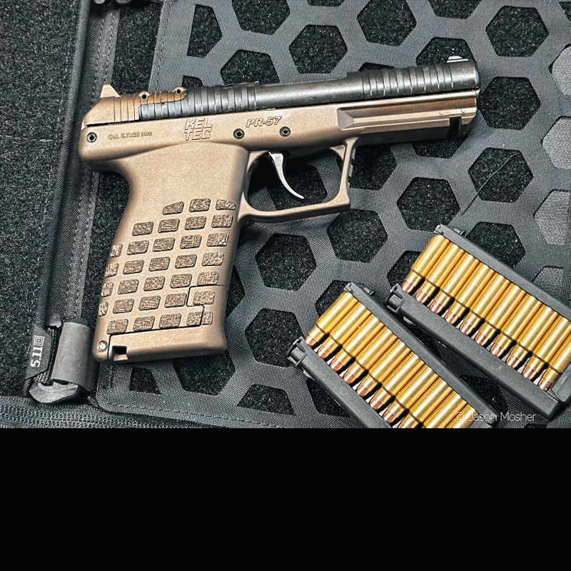 KelTec PR57 on a black web surface with two stripper clips loaded with ammo. 