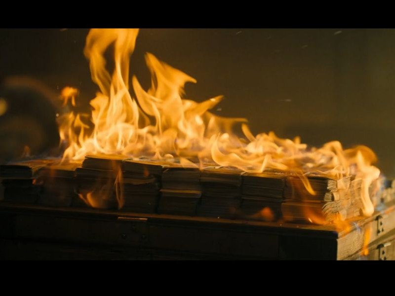 A picture of a stack of money on a pallet, burning.