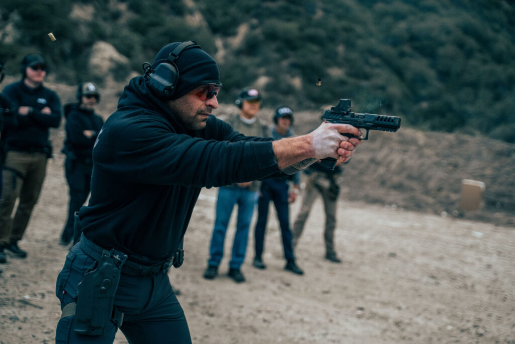 Safariland CADRE Paul Costa shooting a handgun on outdoor range with students observing.