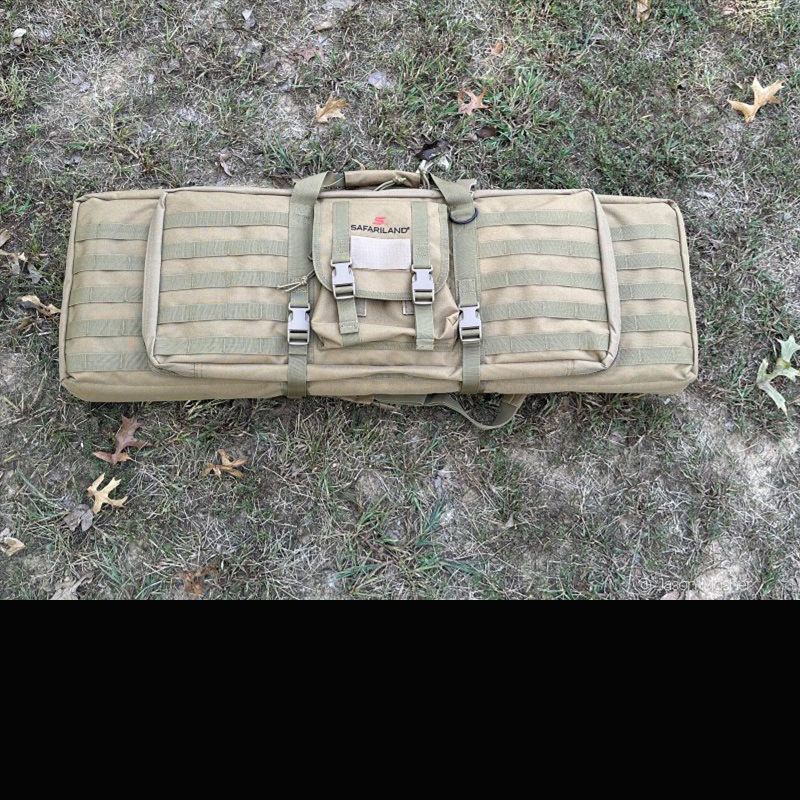 A brown rifle case laying on the ground in the grass. 