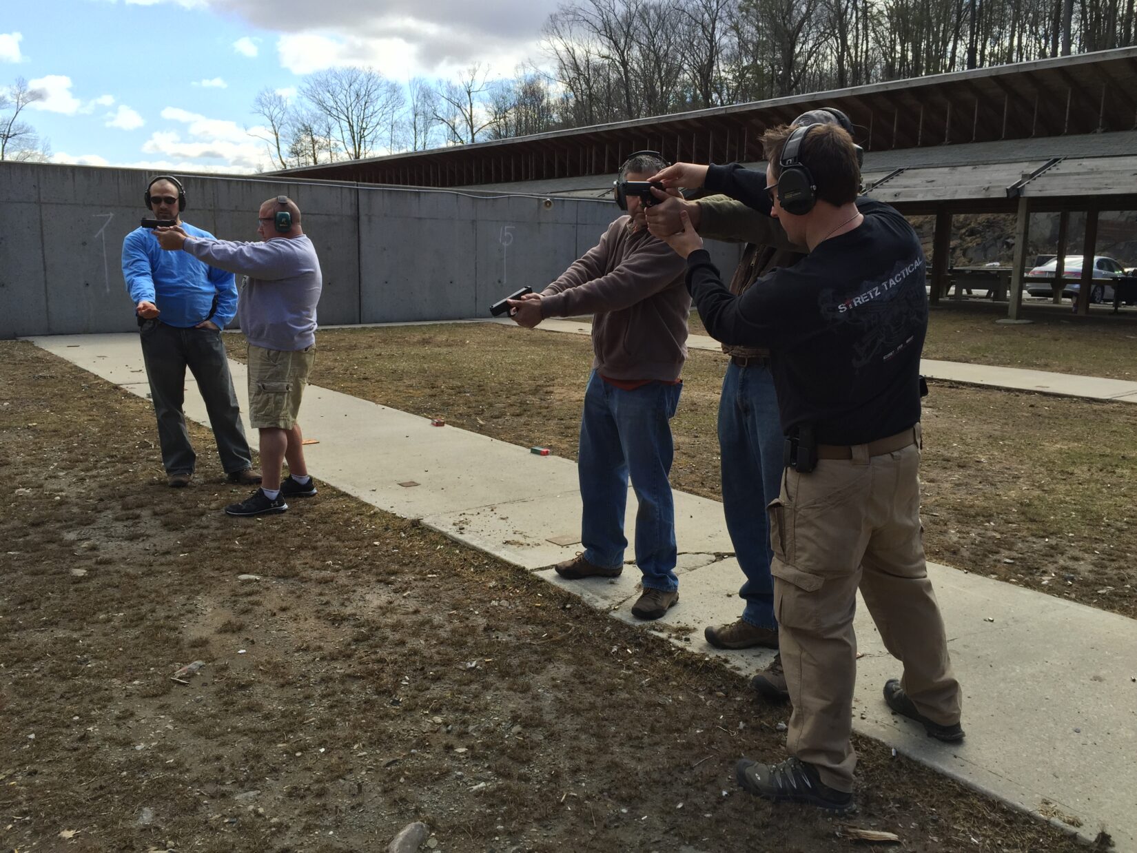 Firearms instructor Ken Stretz of Stretz Tactical adjusts a student's grip in his handgun marksmanship class