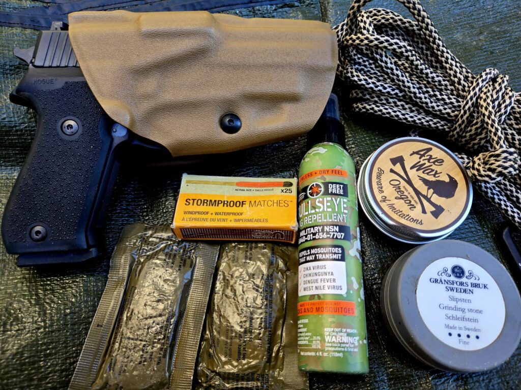 A SIG P220 pistol, trioxane bars, storm matchets, bug spray, cordage, and axe maintenance items