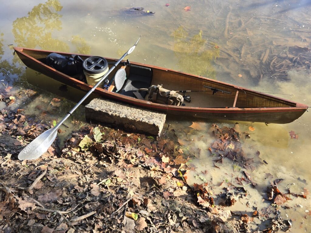 A canoe on a river bank loaded with equipment