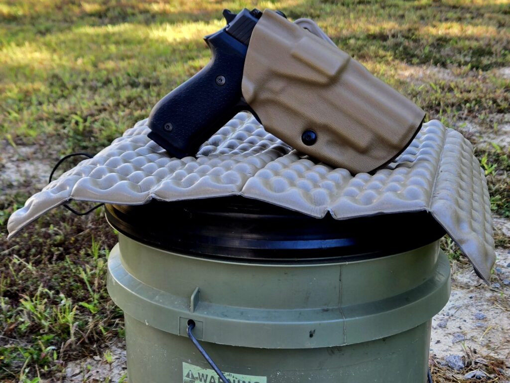 A SIG P220 pistol in a holster on top of a folding camping seat