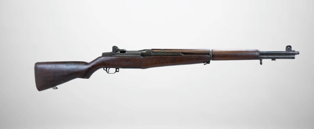 Studio shot of a wooden-stocked M1 Garand semi-automatic rifle.
