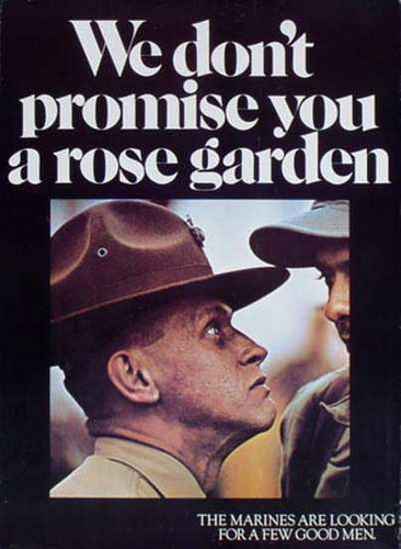 A famous vintage recruiting poster for the U.S. Marines. The text reads: "We don't promise you a rose garden" and "THE MARINES ARE LOOKING FOR A FEW GOOD MEN." A Drill Instructor in a "Smokey Bear" hat is pictured, looking up intently at another person.