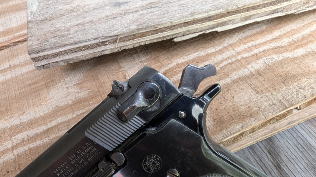 Extreme close-up of the rear of the Model 59's slide and hammer, showing the slide-mounted safety/decocker lever and the serrations.