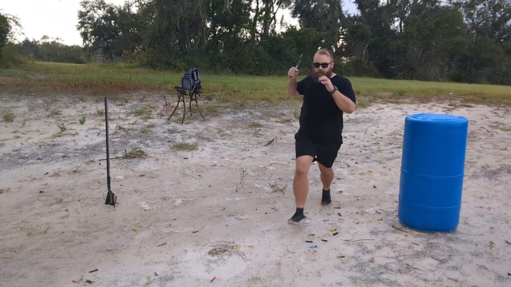 Man running forward at a shooting range while holding a knife