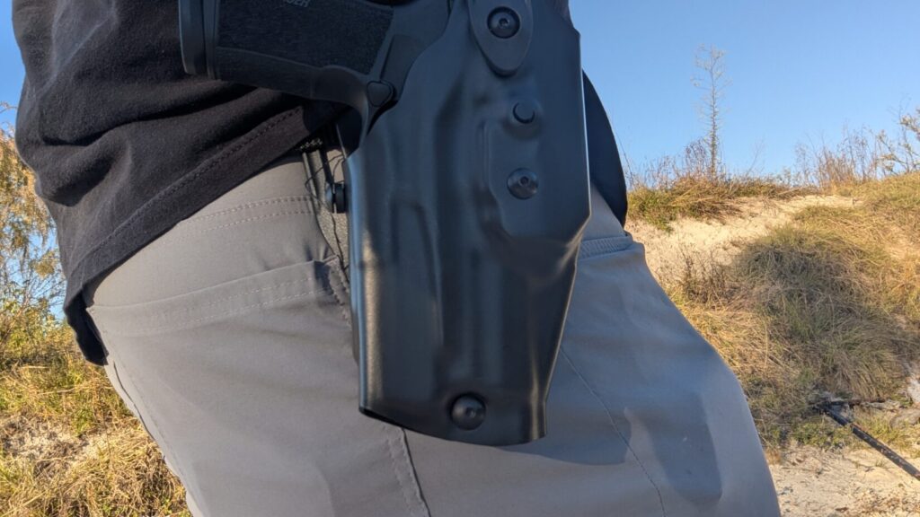 Underside view of a black Safariland holster on a painted concrete surface.