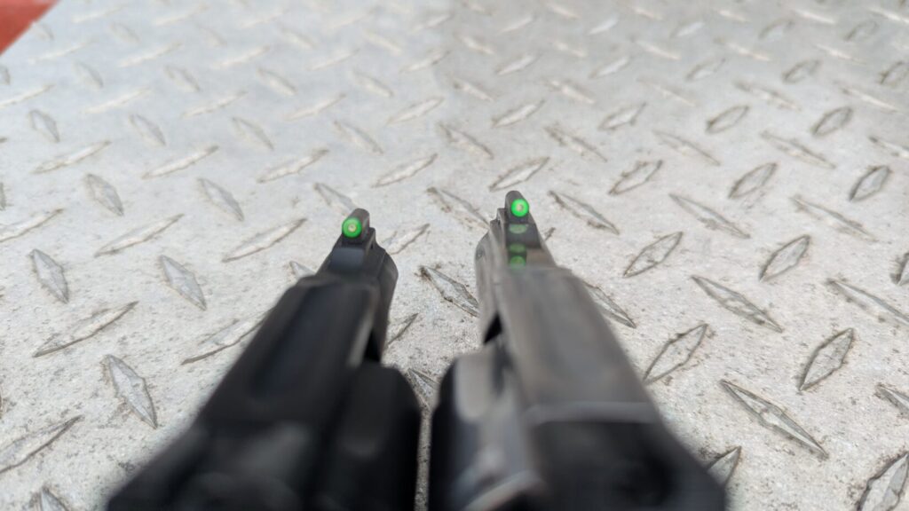 Close-up of the green fiber optic front sights of the two S&W revolvers.