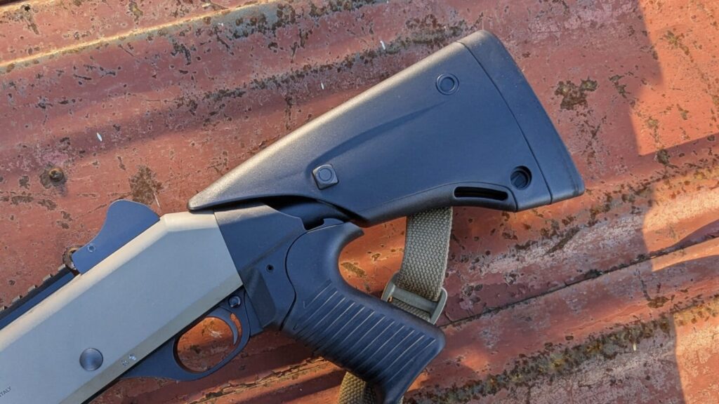 Close-up of the Benelli M4's fixed pistol grip stock and receiver area.
