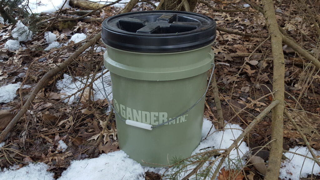 A 5 gallon bucket with a gamma seal lid on a snowy backdrop