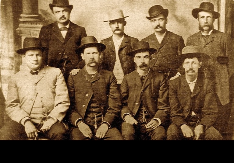 Wyatt Earp (sitting second from left), Bat Masterson (standing second from right), and other deputy marshals during the Wild West era. Taken June 1883.