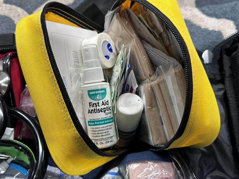 A yellow zip up bag containing medical supplies in it. 