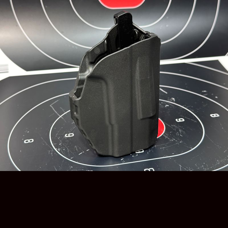 A black holster sitting on top of a target with a red center. 