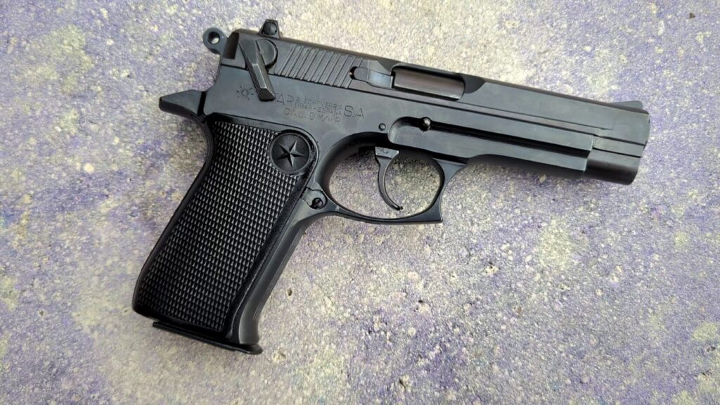 Overhead view of a Star 30M pistol on a gray concrete background.