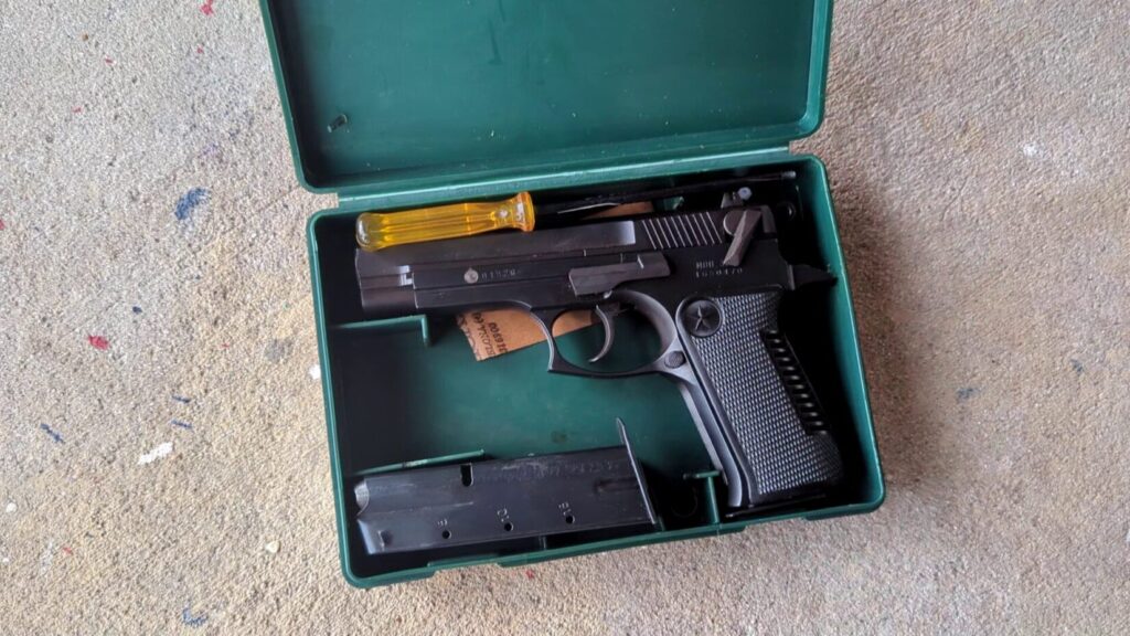Star 30M pistol, magazine, and cleaning tools inside its open green plastic case.