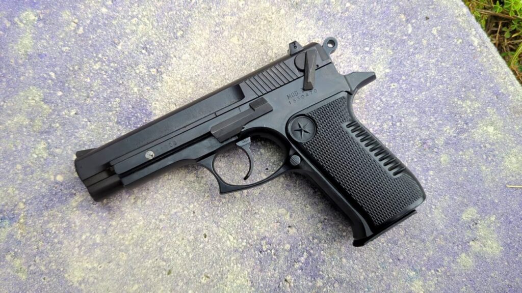 Overhead view of a Star 30M pistol on a gray concrete background.