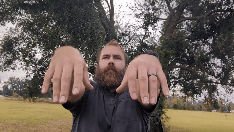 man outdoors doing grip exercises