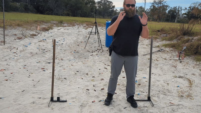 Man shooting handgun with a two-handed grip moving laterally and drawing