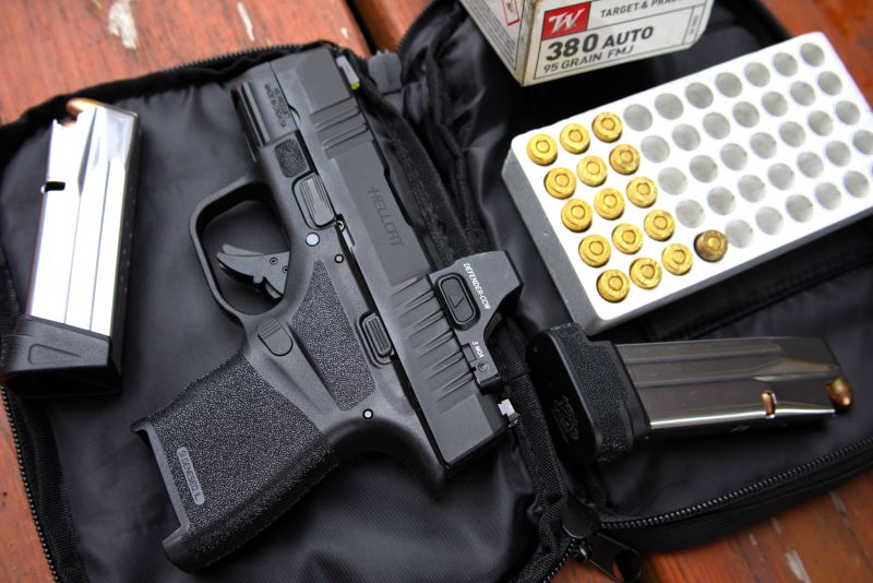 springfield hellcat sitting on  its case with a box of ammunition