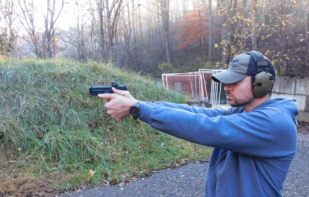 Man firing a semiautomatic pistol on a range