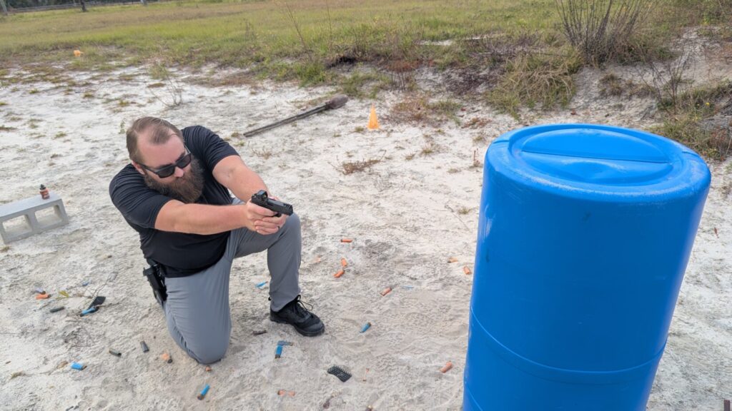 A full shooting lane with orange cones, targets, and a blue barrel obstacle