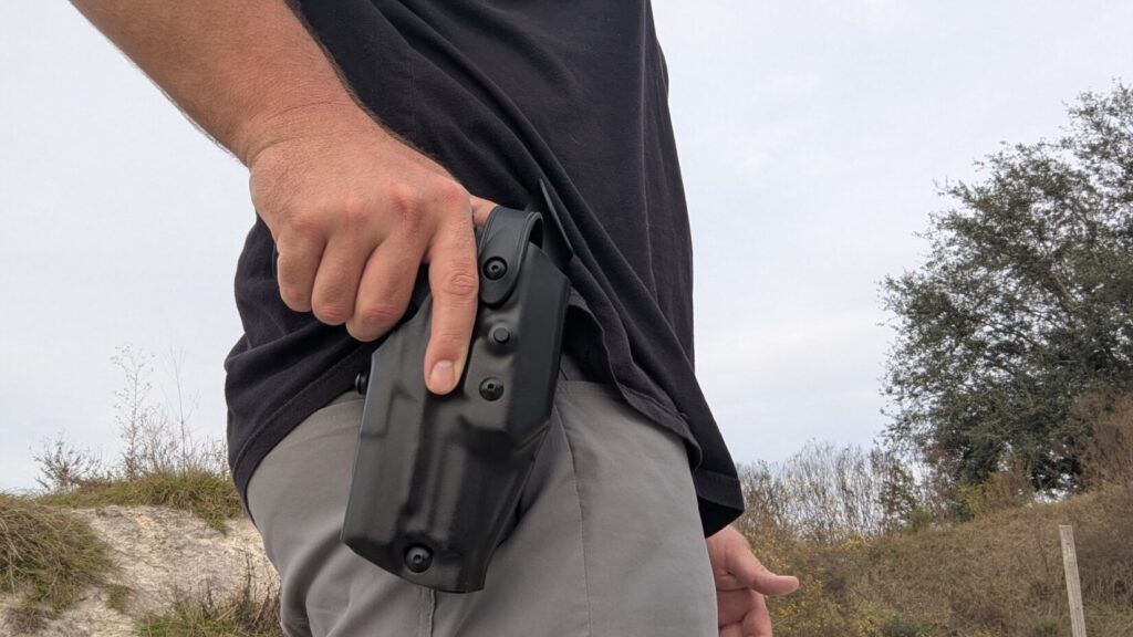 Man gripping firearm located in holster