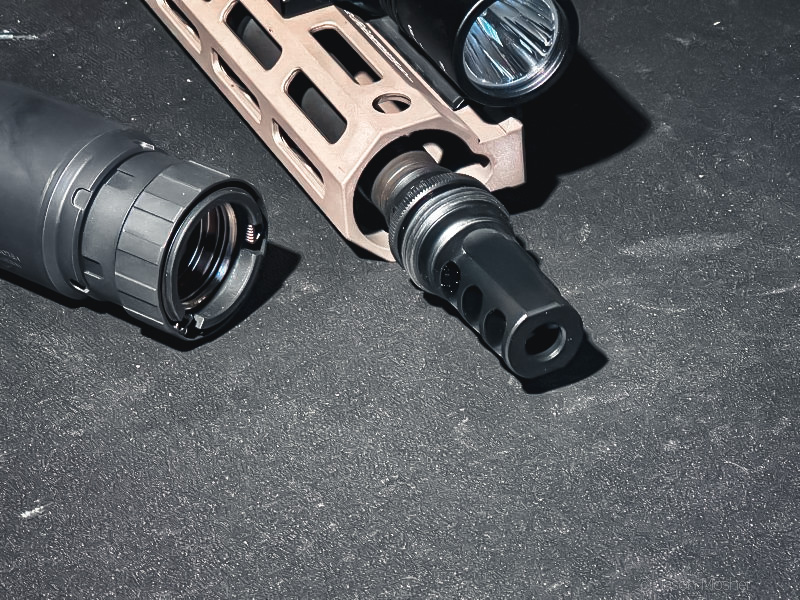 A close up view of the back of the Velos silencer and the ASR flash hider. 