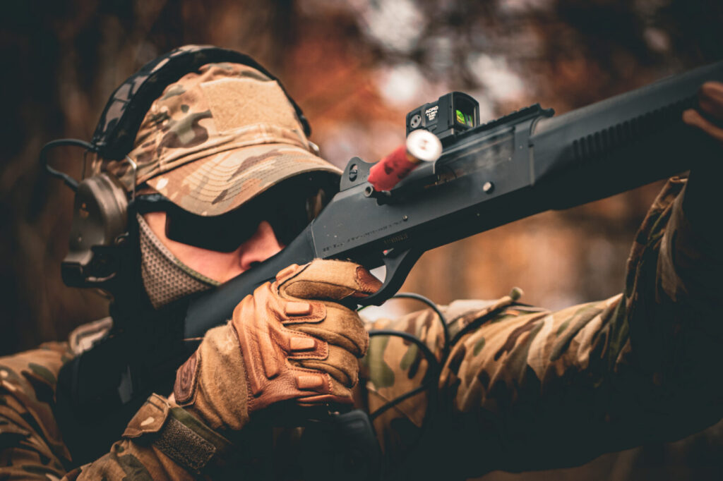 Aimpoint Acro P-2 with 9 MOA red dot mounted on a tactical shotgun.