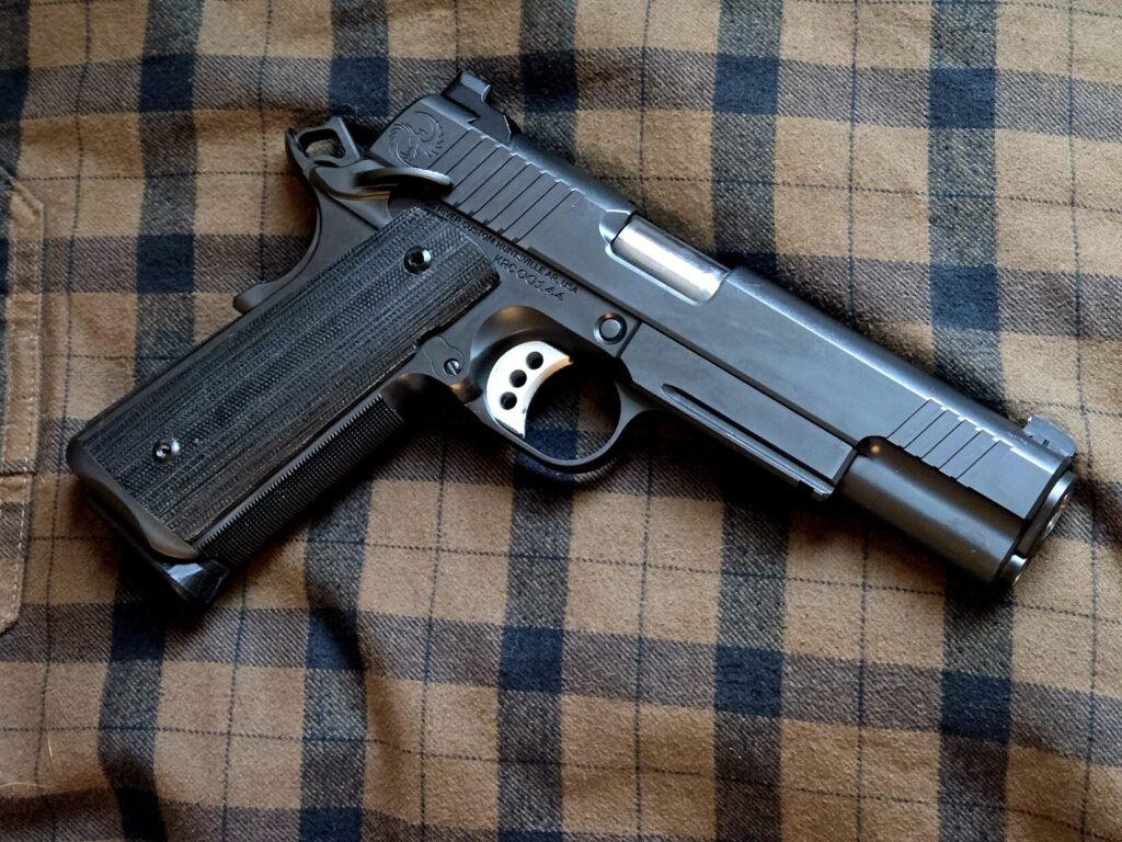 A 1911 pistol on top of a plaid background