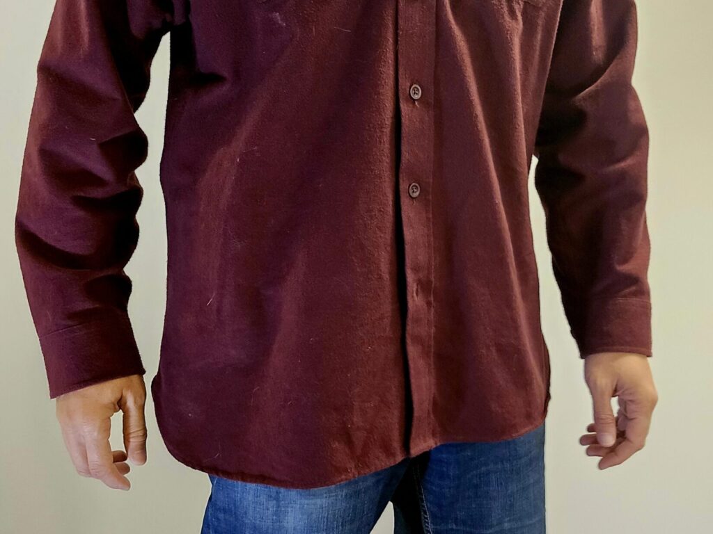 A man in a dark maroon shirt and blue jeans.