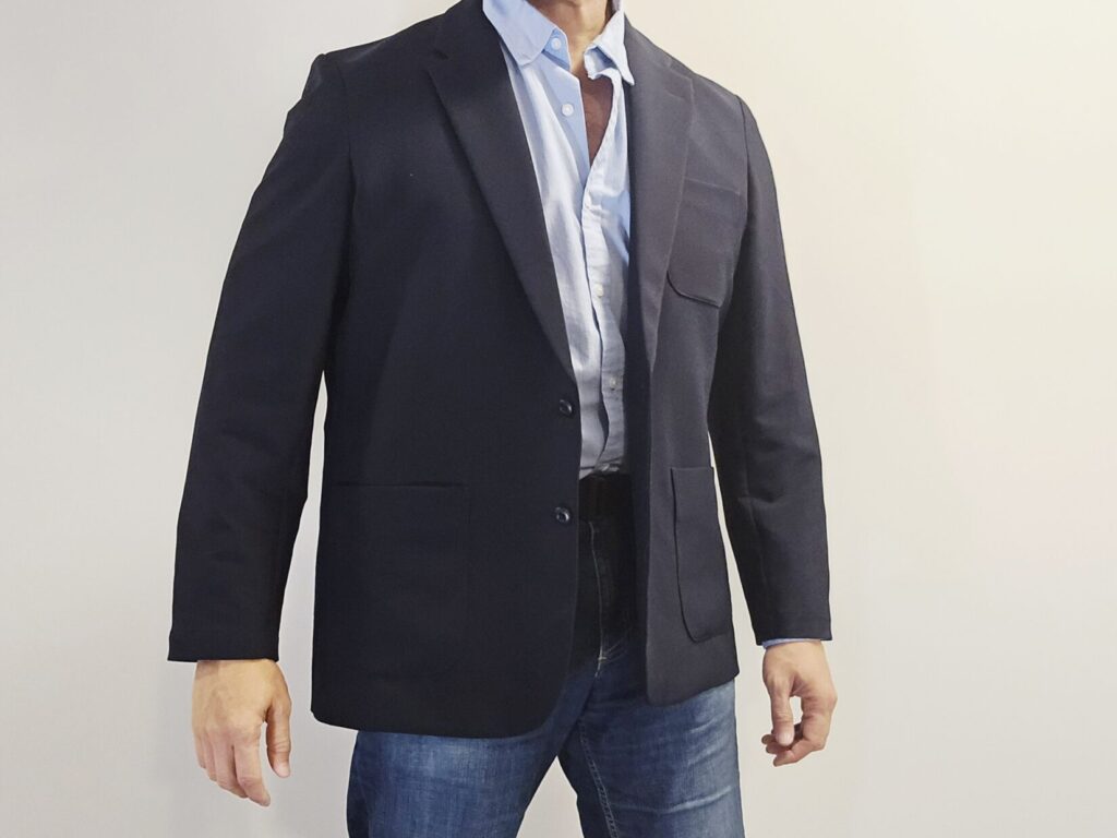A man in a blue sports coat, shirt, and jeans