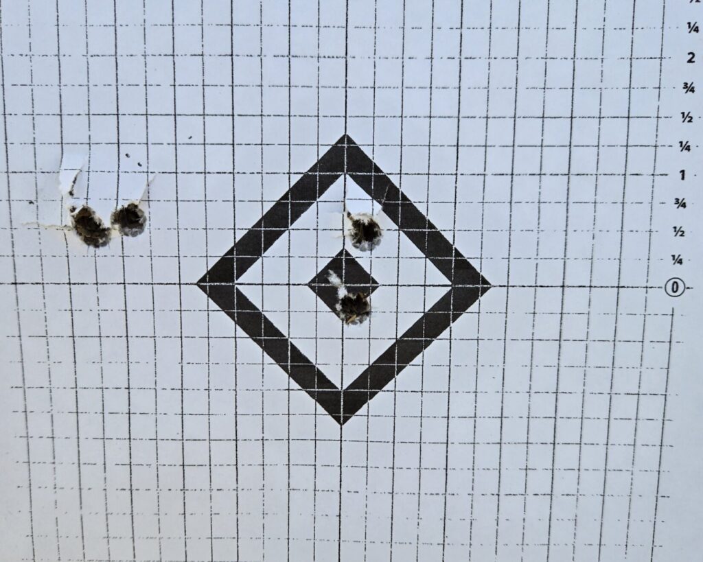 Target showing a zero shift after transit — three initial shots off-center before adjustment, followed by two on-target rounds