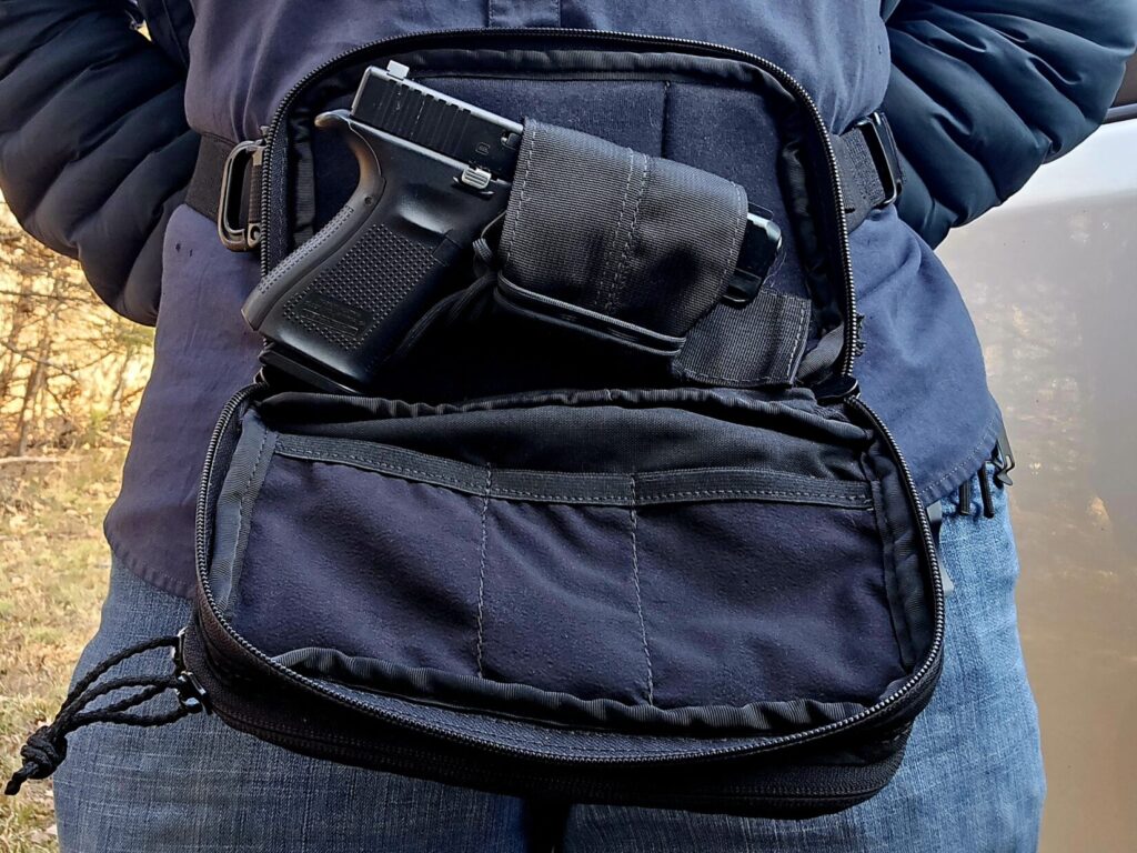 A glock pistol carried inside of a black fanny pack