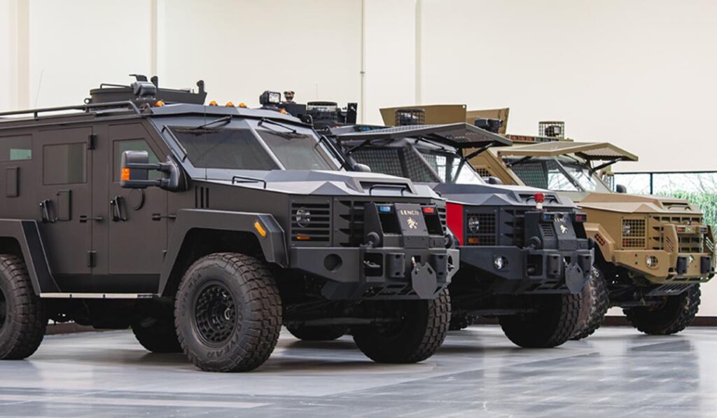 Three Lenco BearCat armored vehicles parked side-by-side in black, gray/red, and tan