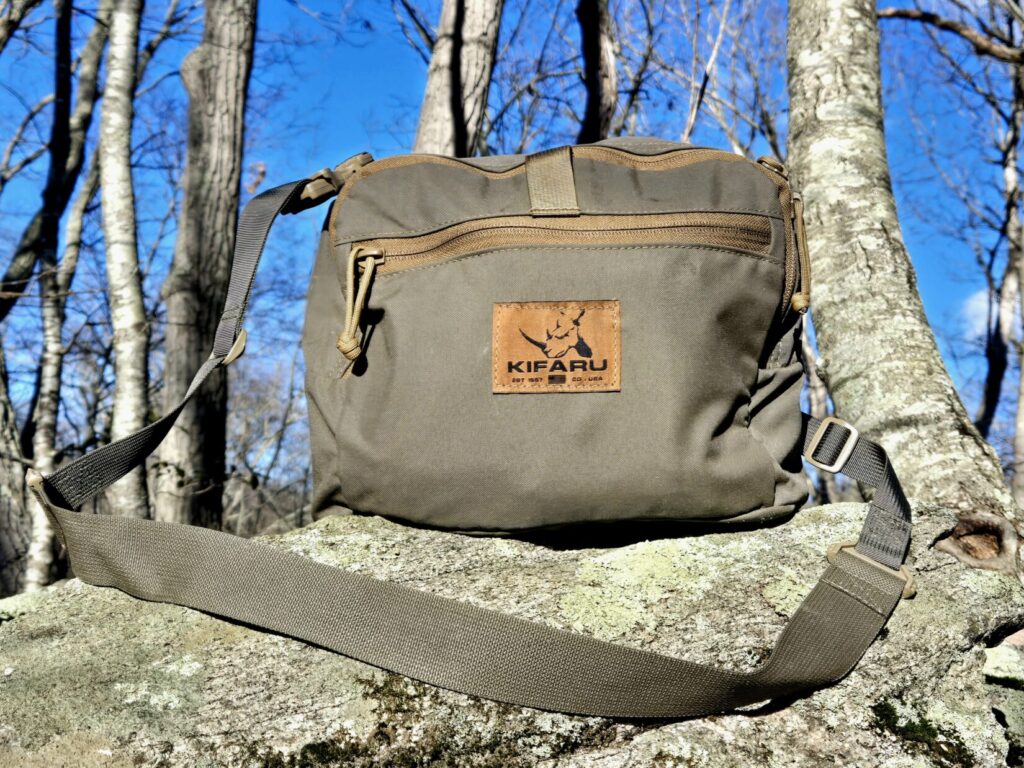 A shoulder bag resting on a rock with a blue sky in the background
