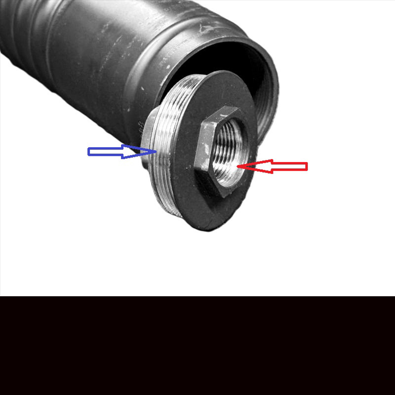 A black silencer with a silencer mount leaning up against it and arrows showing where the threads are. 