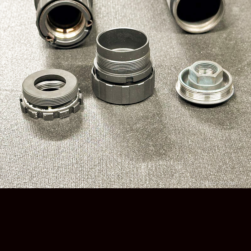 Multiple silencer mounts on a grey table. 