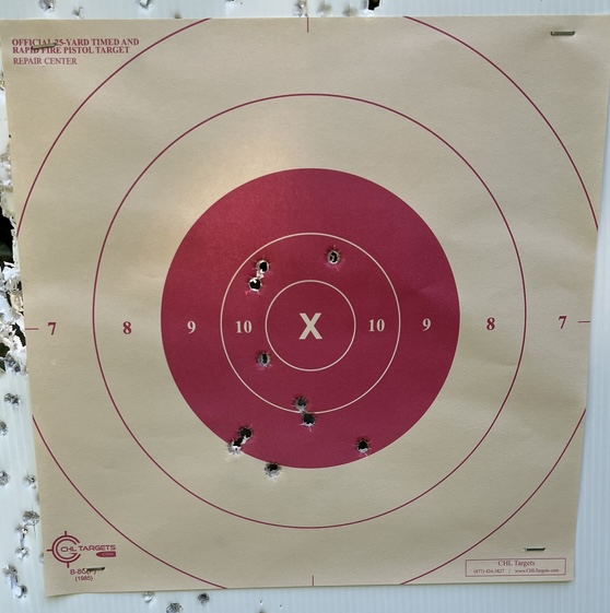 in this picture is a red B8 bullseye target after being shot at 25 meters
