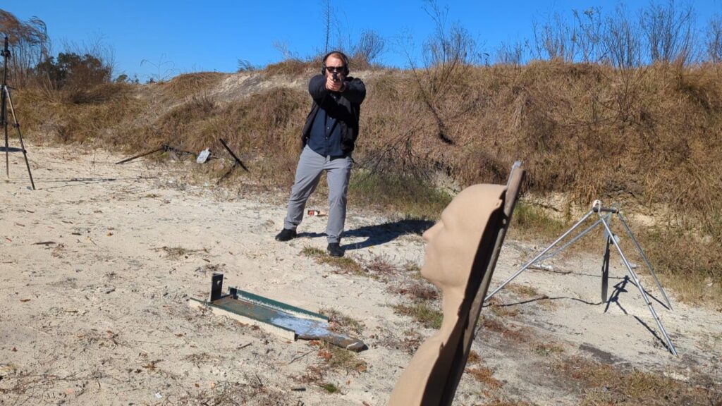 Shooter engaging steel target, seen from behind target.